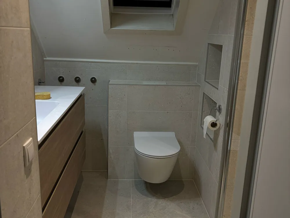 Badkamer op zolder met badmeubel en hangend toilet, gerenoveerd door De Badkamerspecialisten